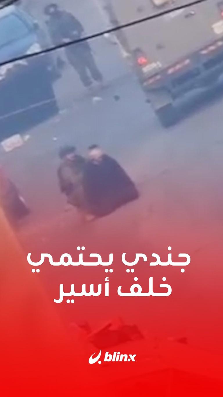 جندي يحتمي خلف أسير