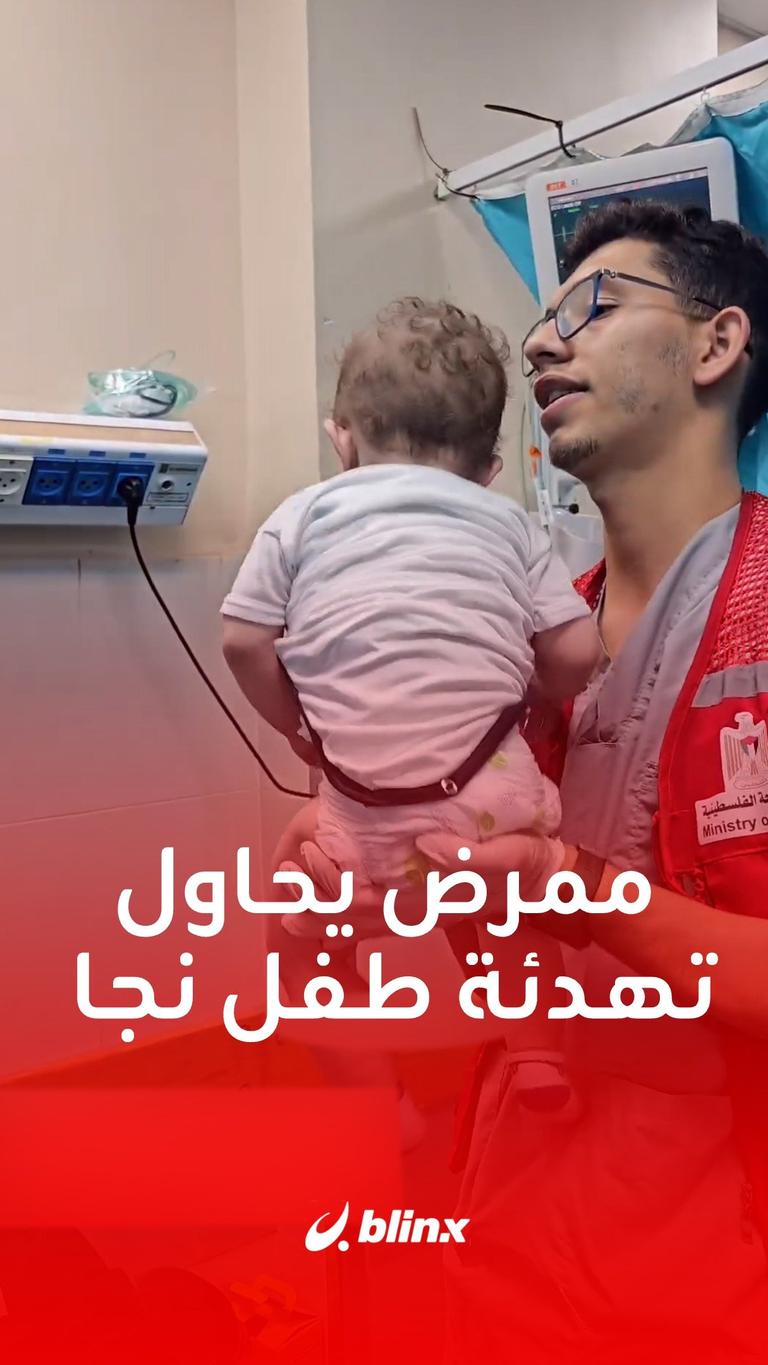 ممرض يحاول تهدئة طفل نجا من غارة إسرائيلية في #غزة